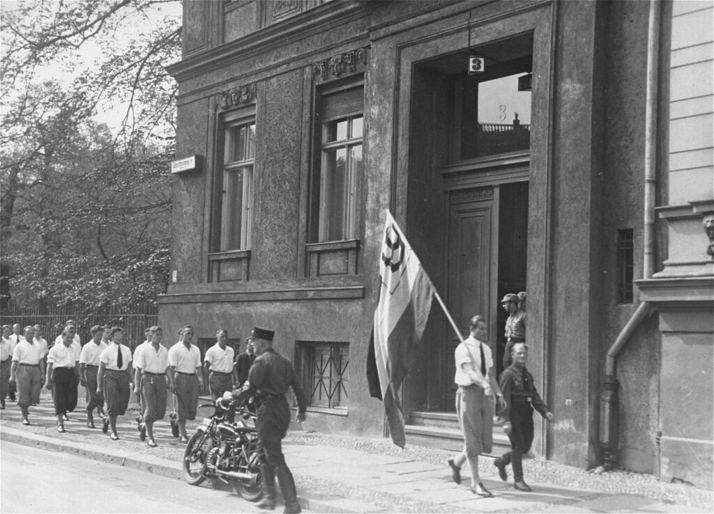 Crowd gathered outside the Institut für Sexualwissenschaft in Berlin as Nazis burn books from the world's first transgender health clinic, 1933